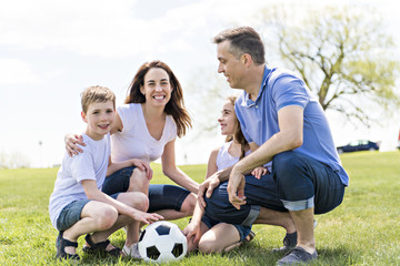 Family of four outdoors in a field having fun