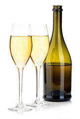 Two glasses of champagne on the background of brown bottles close-up isolated on a white.