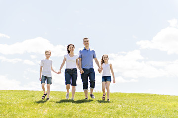 Family of four outdoors in a field having fun