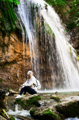Young woman near waterfall