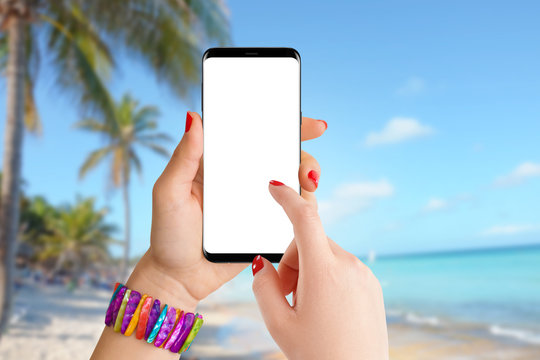 Girl on the beach using phone with empty screen