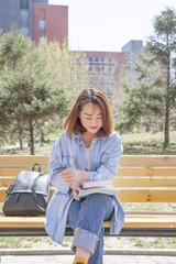 Young woman reading on bench