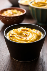 Shrikhand & Amrakhand served in different size bowl in group. Selective focus