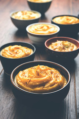 Shrikhand & Amrakhand served in different size bowl in group. Selective focus