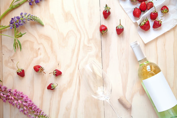 White wine bottle with glass and strawberry