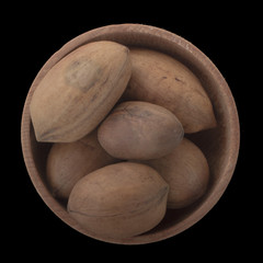 Obraz premium pecan in wooden cup isolated on black background. top view