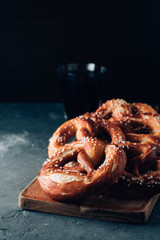 Freshly baked homemade soft pretzel with salt on rustic table. Perfect for Octoberfest. Toned image.