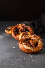 Freshly baked homemade soft pretzel with salt on rustic table. Perfect for Octoberfest. 