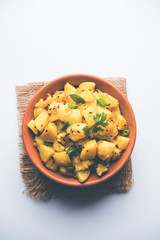 Chatpate Masala Aloo Sabzi fry OR Bombay potatoes served in a bowl, selective focus