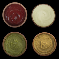 set of sauce in wooden cup isolated on black background. top view