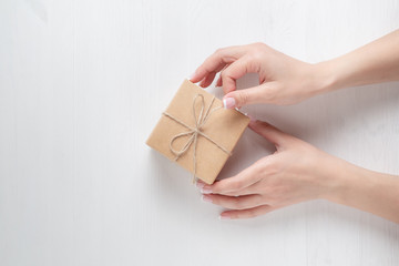 hands of a young girl opening a gift box on a white background