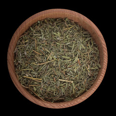 dried thyme in wooden cup isolated on black. top view