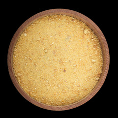 ground dried orange rind in wooden cup isolated on black. top view