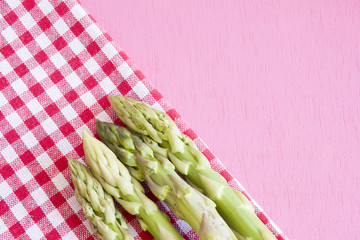 fresh asparagus on napkin and on a wooden pink background.space for your text