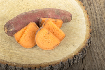 heap of sweet potatos on wooden background