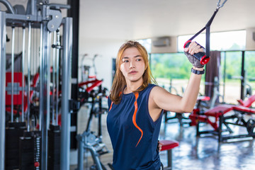 Fototapeta na wymiar Young Asian woman working out and doing fitness training at a local gym