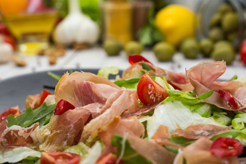 Fototapeta premium Fresh vegetable salad with prosciutto