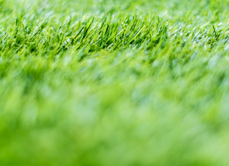 Texture of plastic artificial grass of school yard by shallow depth of field