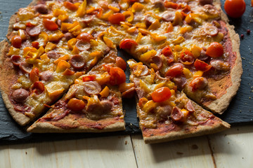 family is very fond of pizza. the hands of children and adults over homemade pizza made by own hands, on a stone dish and white table of boards