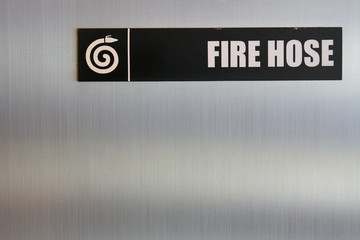 Fire hose sign on metal plate.