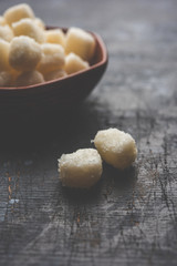 Chena Murki is indian sweet food served in ceramic bowl over moody background. selective focus