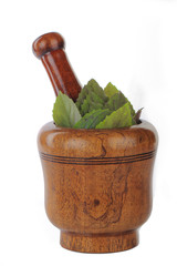 basil on wooden mortar isolated on white background