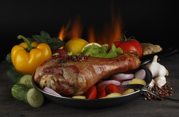 chicken with vegetables on wooden tables on fire background
