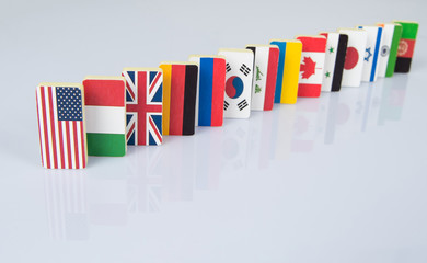 The domino effect with tiles of flags of different countries of the world. conceptual photo,...