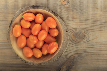 Kumquat in wooden plate on wooden table