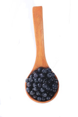 heap of bilberries in wooden spoon isolated on white background. top view