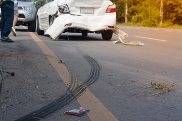 A car accident. Traces of braking tires on the road surface. Warm light.