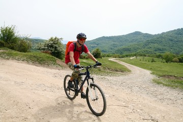 Cyclist rides on a dirt road in the mountains