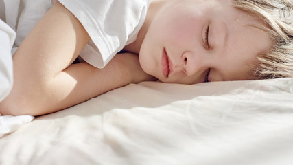 Closeup photo of teenager boy sleeping and dreaming in bed