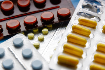 Multi-colored tablets and capsules in packages.