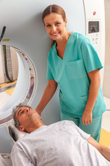 Happy female doctor assisting patient undergoing MRI scan