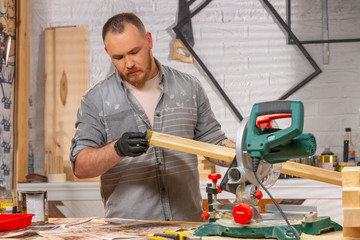 the joiner covers varnish the wooden part in workshop