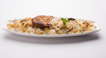 Authentic Fish Biryani served in a white plate over white background, selective focus