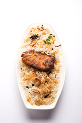 Authentic Fish Biryani served in a white plate over white background, selective focus