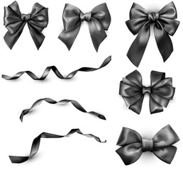 Naklejka premium Black realistic satin bows and ribbons isolated on white.