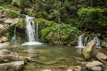Fototapeta na wymiar Small waterfall in mountain environment