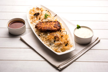 Authentic Fish Biryani served in a white plate over white background, selective focus