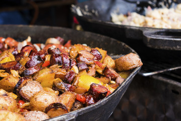 Fast street food, different Steamed Meat , pork sausages and Vegetables in big frying pan. Traditional czech food on market