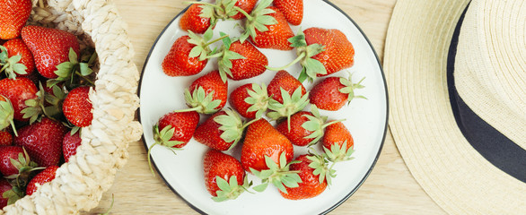 strawberry on a white plate, hat and basket with berries, banner