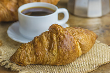 Traditional french breakfast with croissants and cup of coffee close up