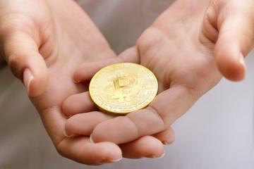 female hands closeup with the coin bitcoin