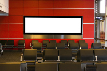 Fototapeta premium Blank billboard on modern red wall in airport with seating,