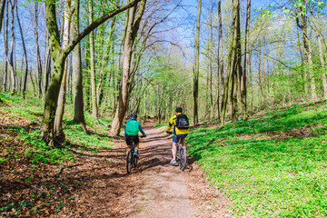 Fototapeta premium couple riding bicycle in forest in warm day