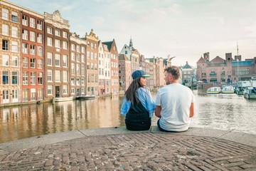 young couple at waterfront Amsterdam city trip Netherlands sunset summer - obrazy, fototapety, plakaty