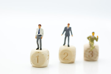 Miniature people : Businessman standing on wooden blocks with sequential numbers '1, 2, 3', win and loser. Image use for business concept.