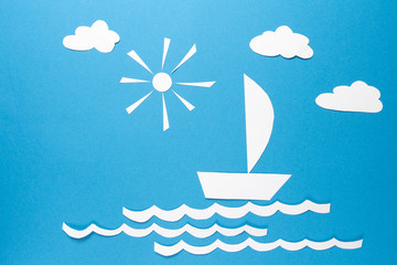 Obraz premium Paper origami boat sails on waves of sea under sun and white paper clouds on blue background. The concept of success and safety. Good conditions. Reliable business.